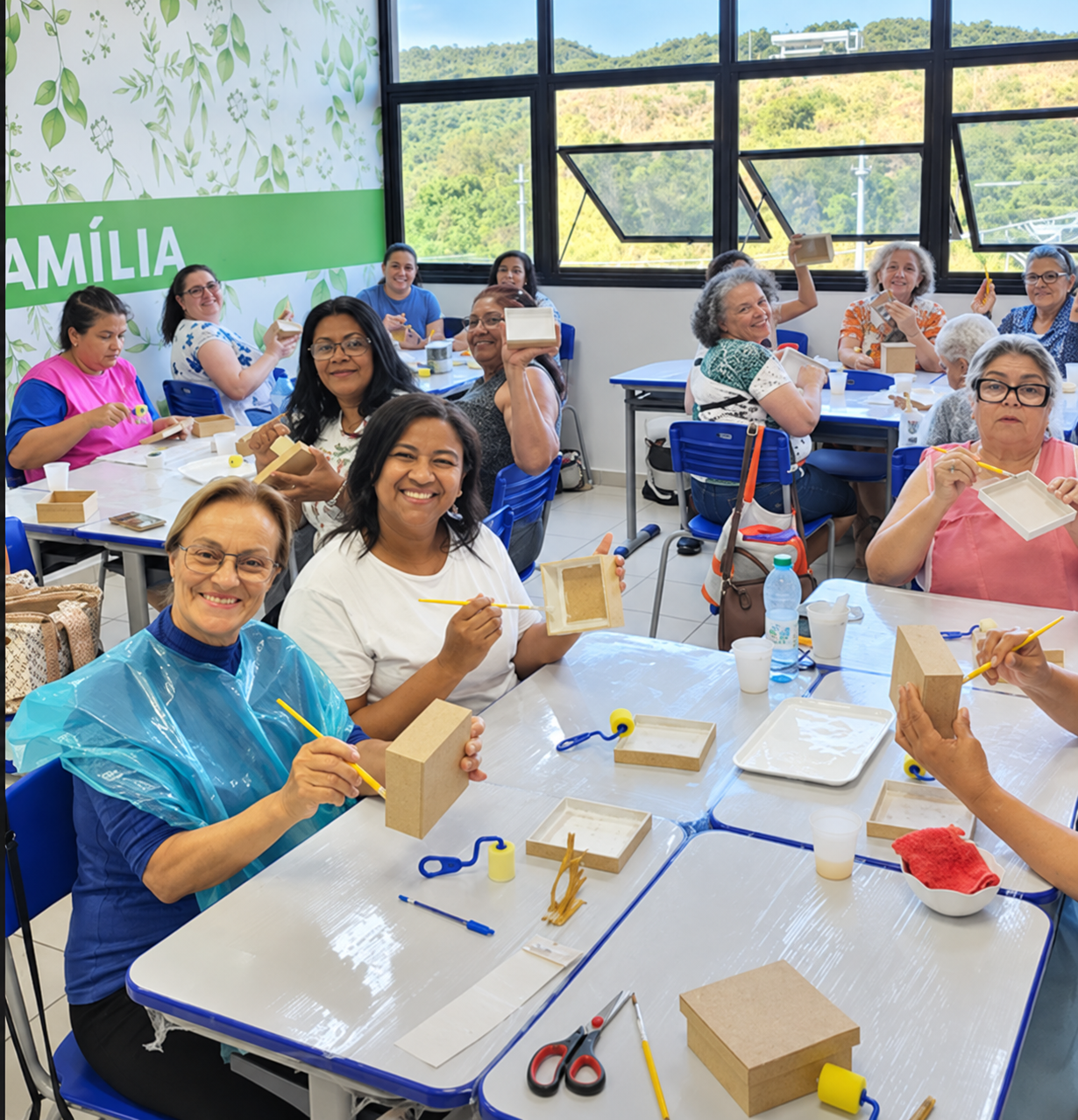Alunas trabalhando com pincéis e caixas de MDF durante a oficina