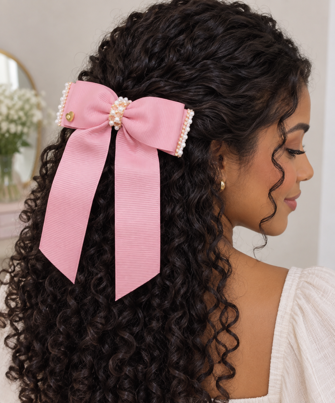 Laço rosa para cabelo com acabamento de pérolas e pequeno coração dourado